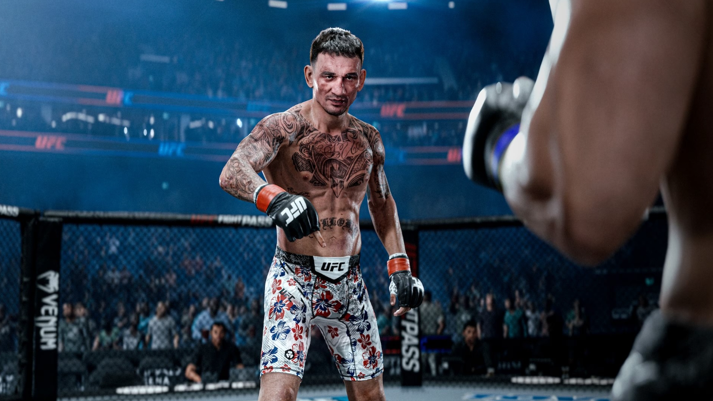 Un luchador de UFC tatuado con pantalones cortos florales señala hacia adelante en un estadio, frente a otro.
