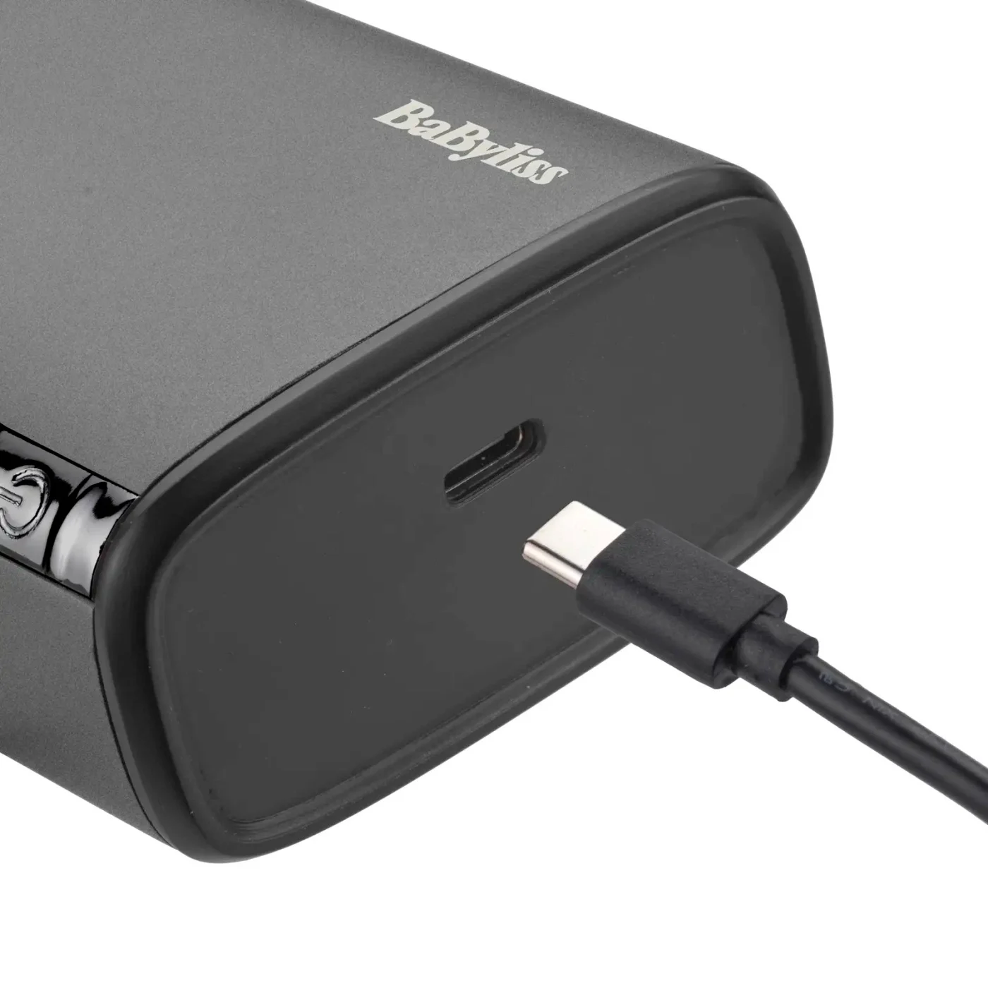 Egy fekete BaByliss készülék, amelybe USB-C töltőkábelt dugnak be fehér háttér előtt.