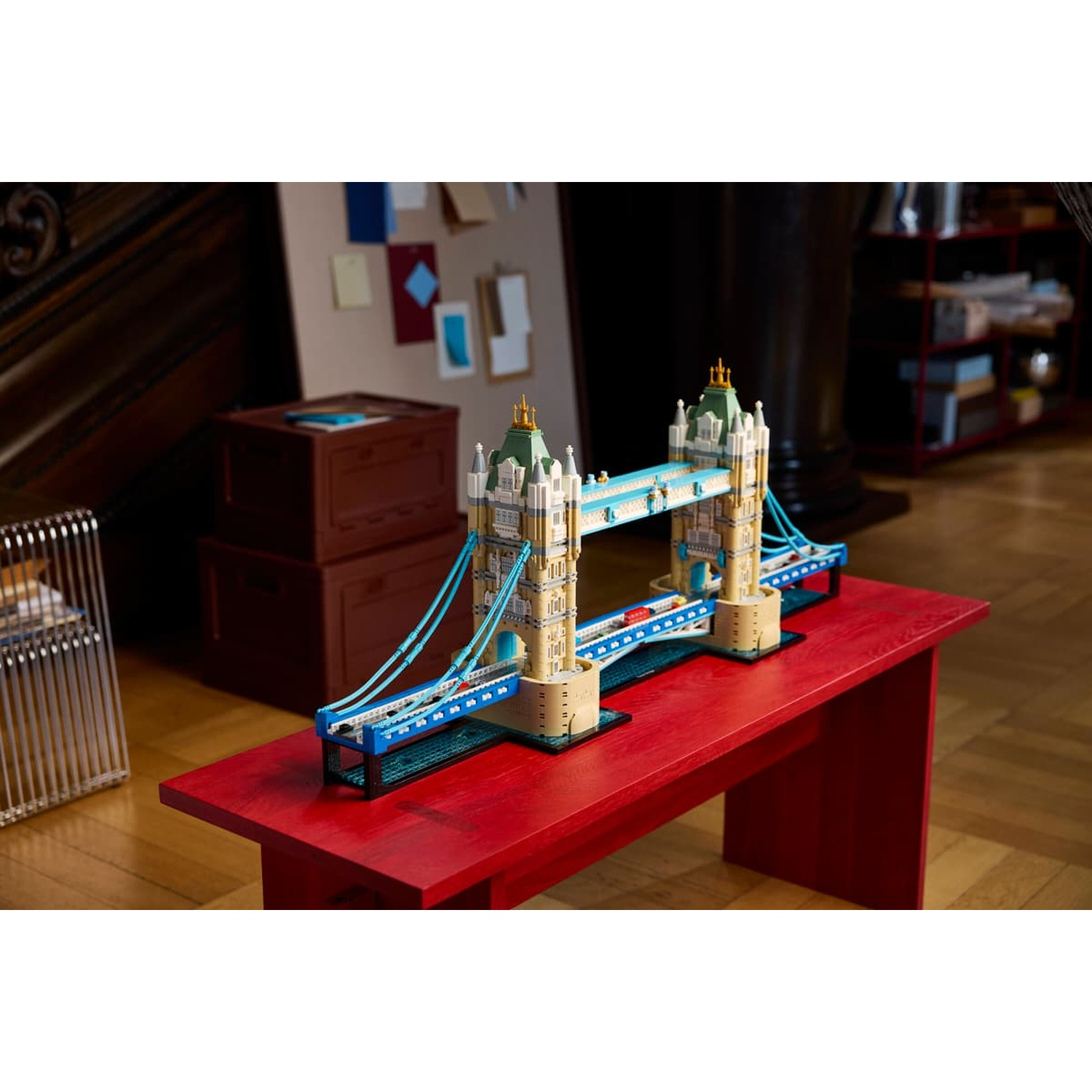 Un modello Lego del Tower Bridge su un tavolo di legno rosso in una stanza.