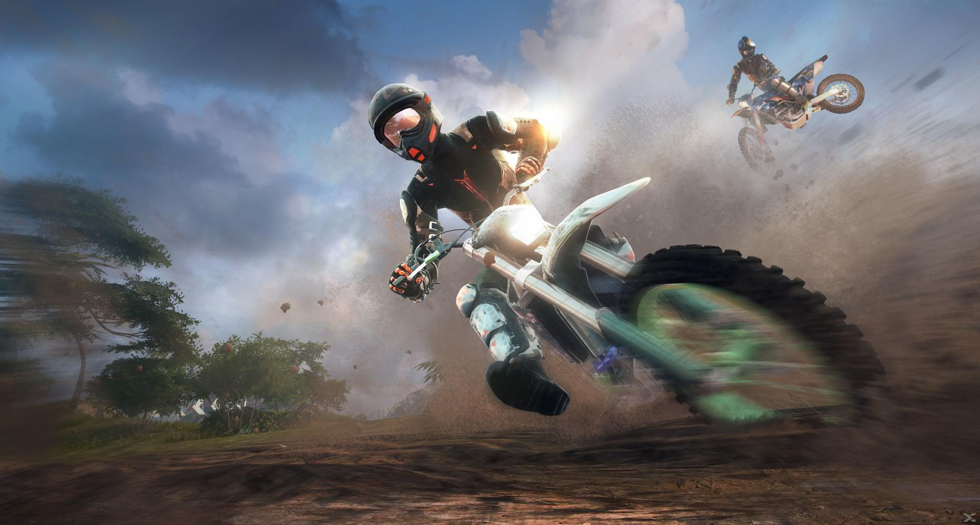 Ein Motocross-Fahrer rast auf einer Schotterpiste und wirbelt Staub auf, während ein anderer Fahrer im Hintergrund springt.