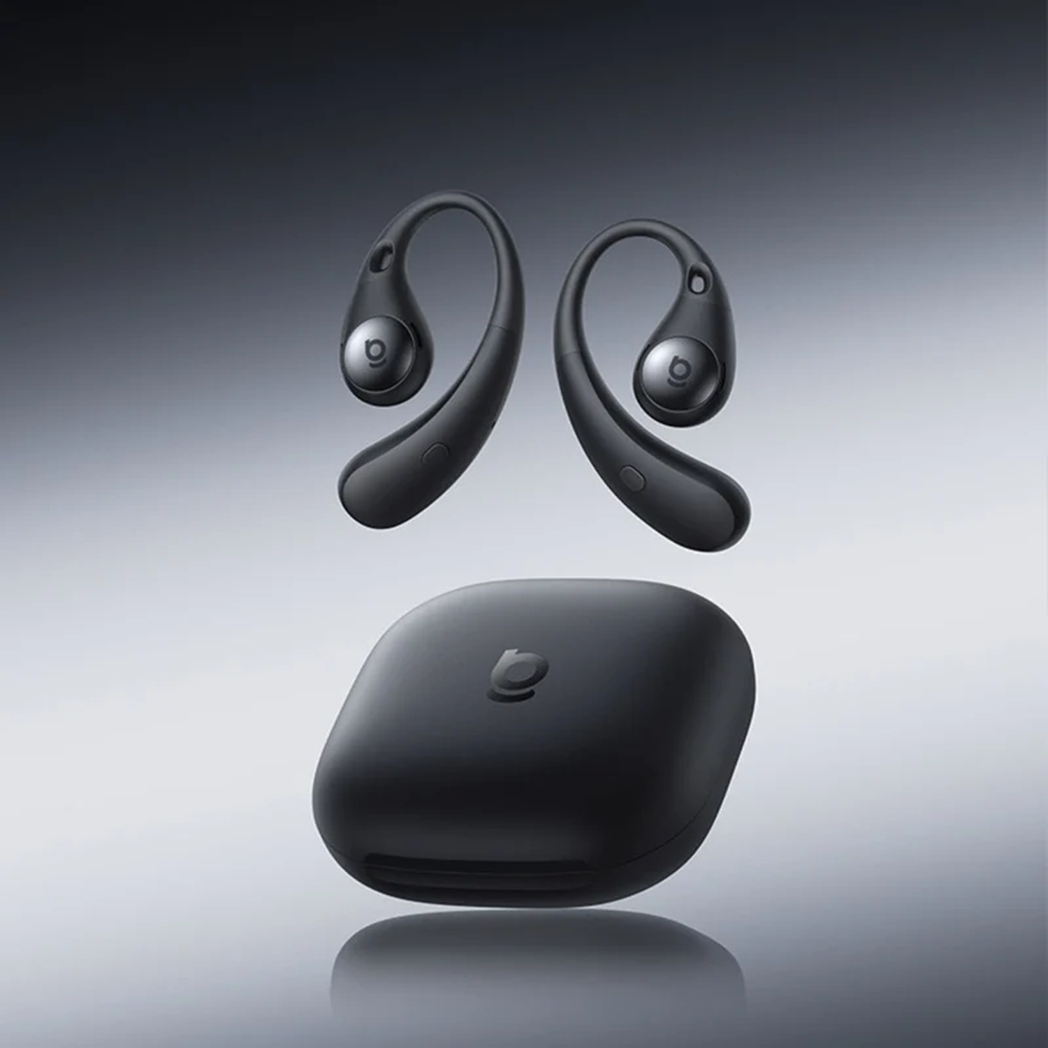 Auriculares inalámbricos negros con ganchos flotan sobre un estuche de carga mate a juego sobre fondo gris.