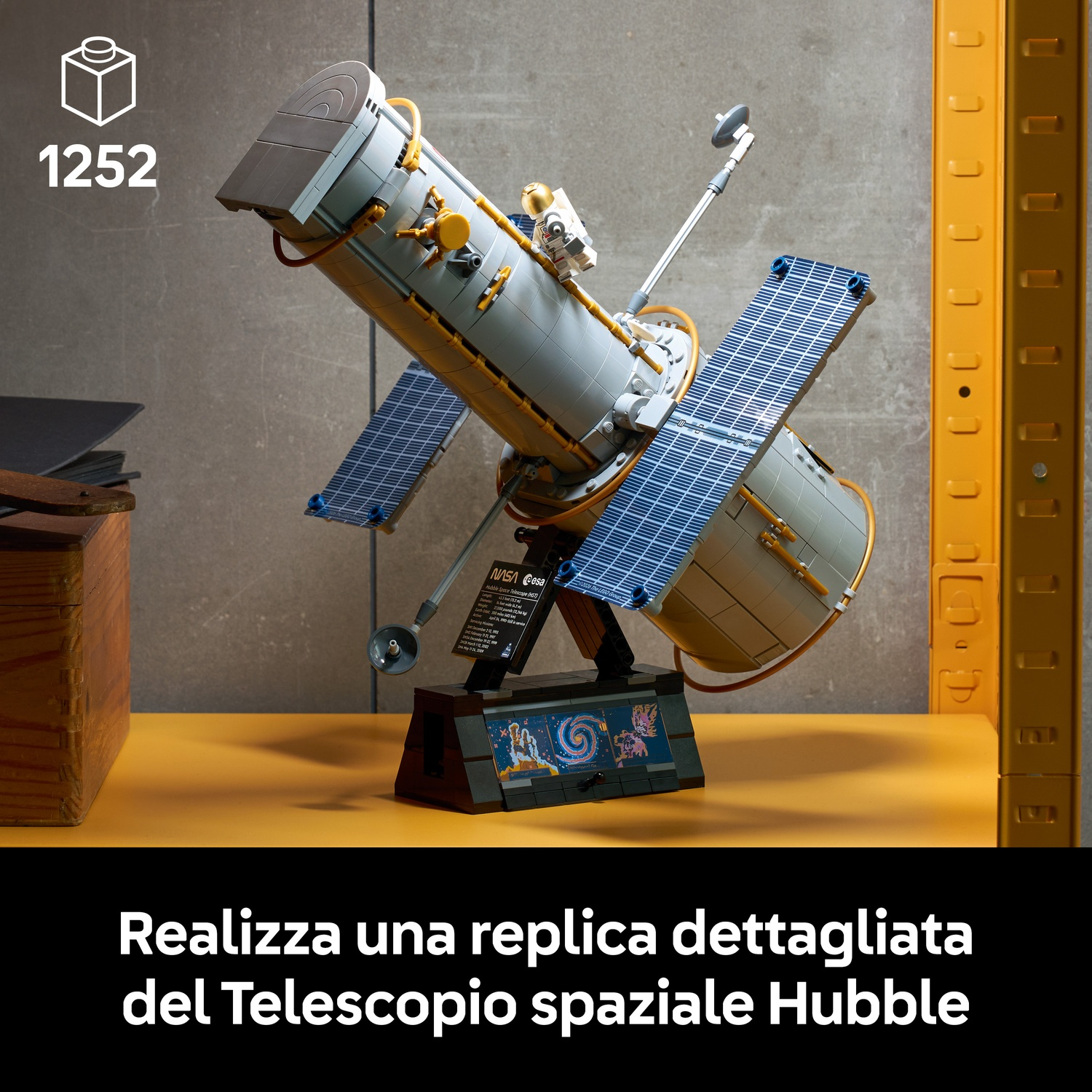 Modello Lego dettagliato del telescopio spaziale Hubble su un supporto contro una parete.