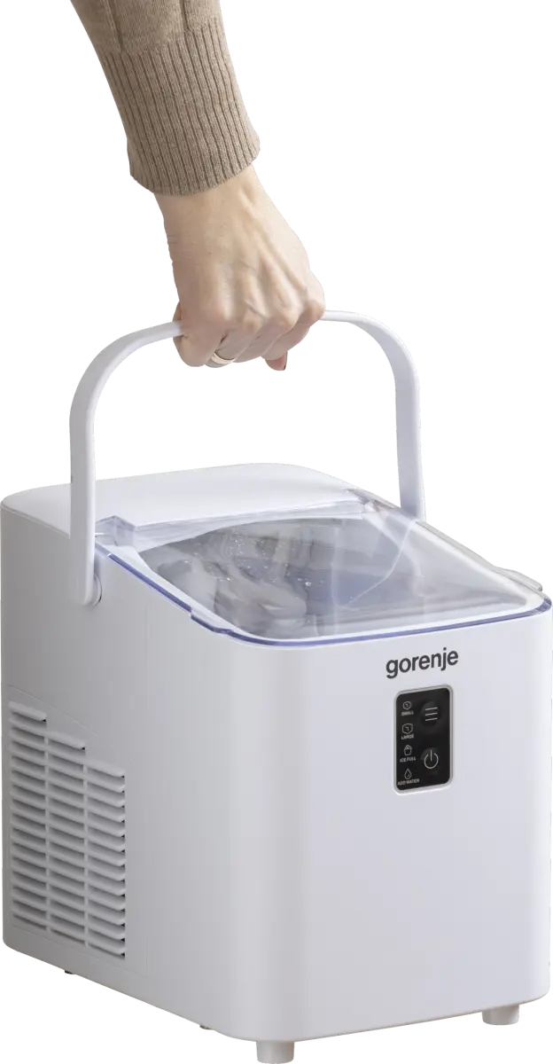 Egy kéz fogja egy hordozható Gorenje jéggép fehér fogantyúját fekete háttér előtt.