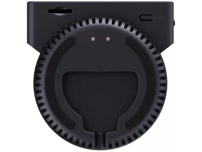 Dispositivo electrónico circular negro con ranuras de ventilación, dos pequeñas luces y puertos arriba.