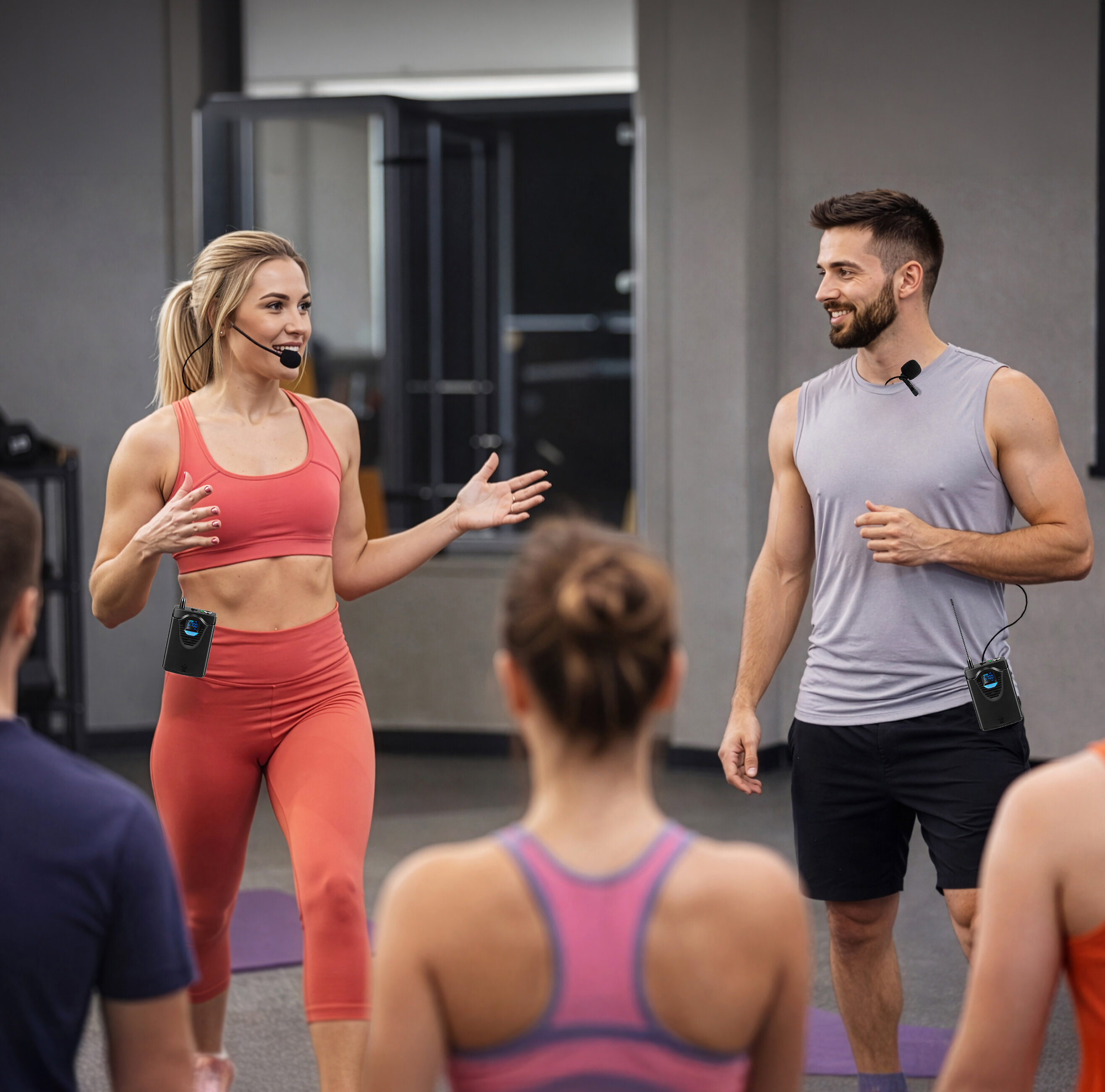 Instruktorzy fitnessu z mikrofonami prowadzą zajęcia w siłowni.