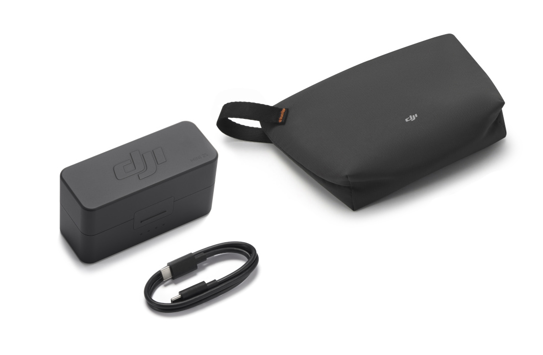 Czarny hub ładowania DJI, kabel USB i mała torba DJI na białym tle.