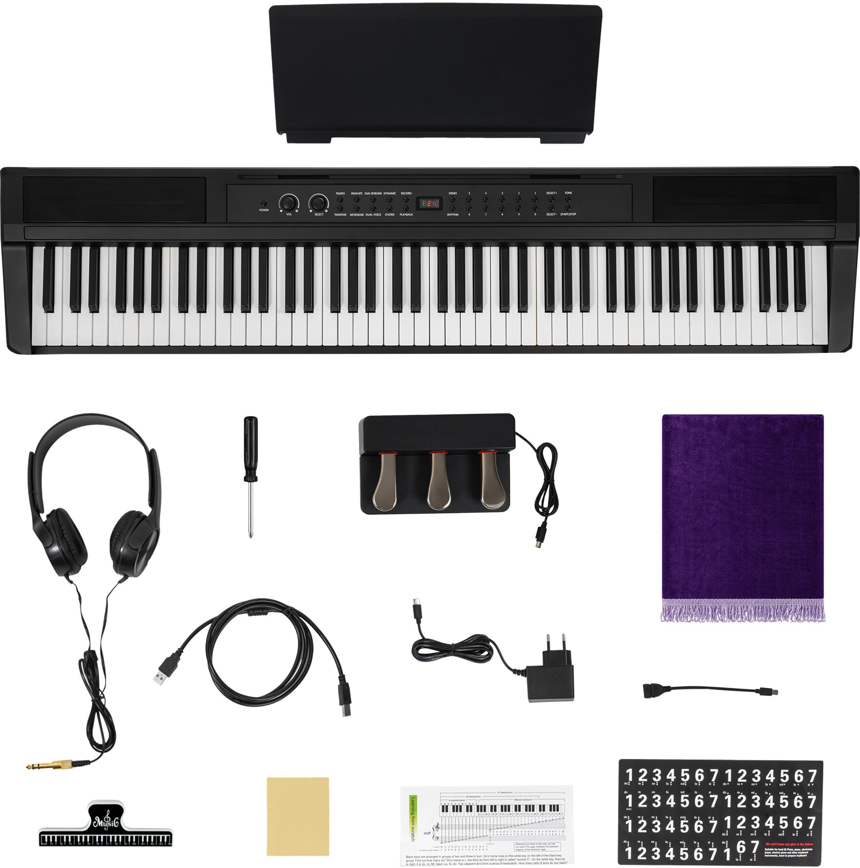 Czarny keyboard, słuchawki, pedał, kable, nuty, ściereczka z mikrofibry i naklejki na białym tle.