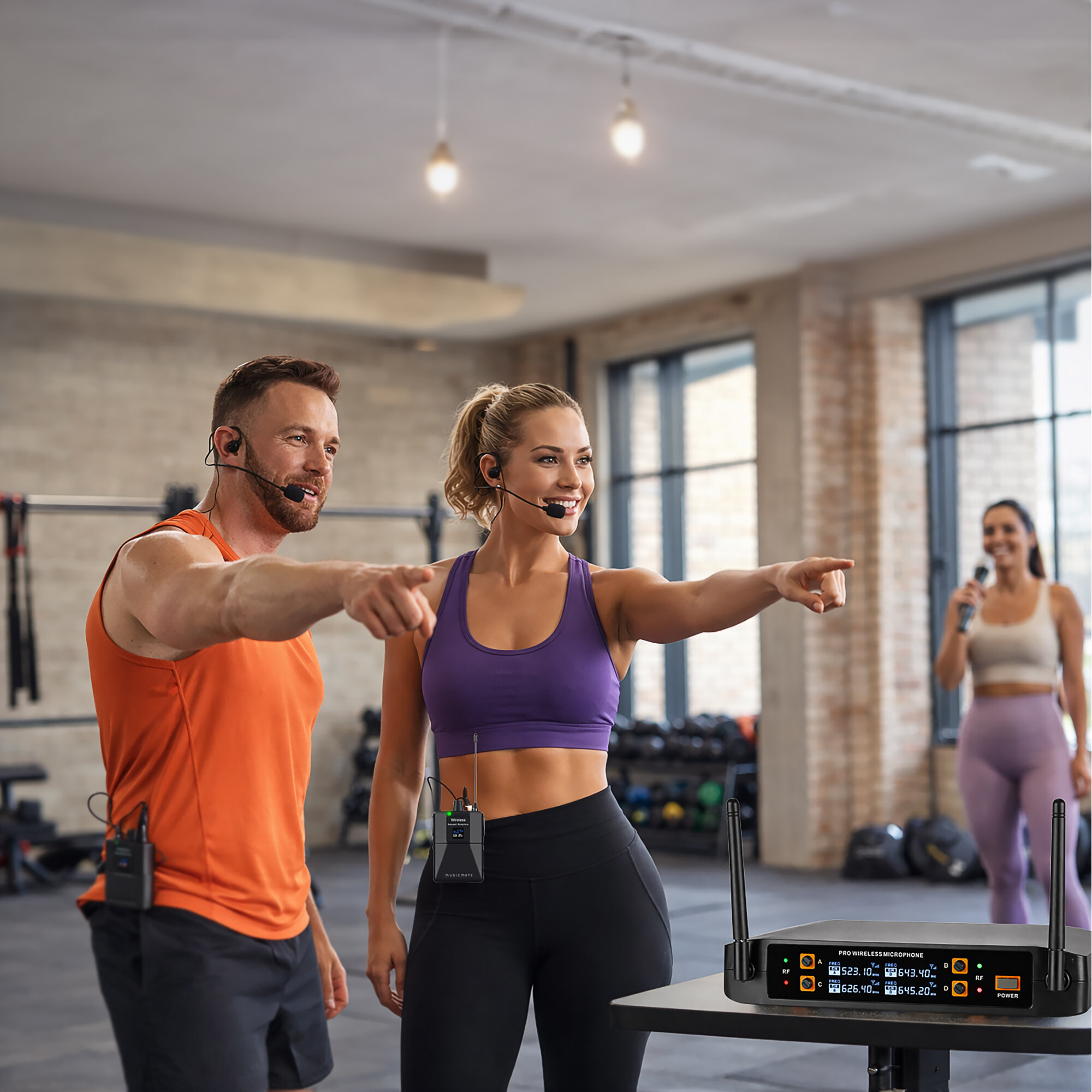 Instruktorzy fitness ze słuchawkami wskazują w jasnej siłowni ze sprzętem w tle.