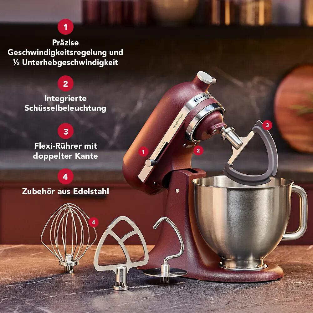 Rote Küchenmaschine mit Edelstahl-Rührschüssel und Zubehör auf dunkler Arbeitsplatte mit deutscher Beschriftung.