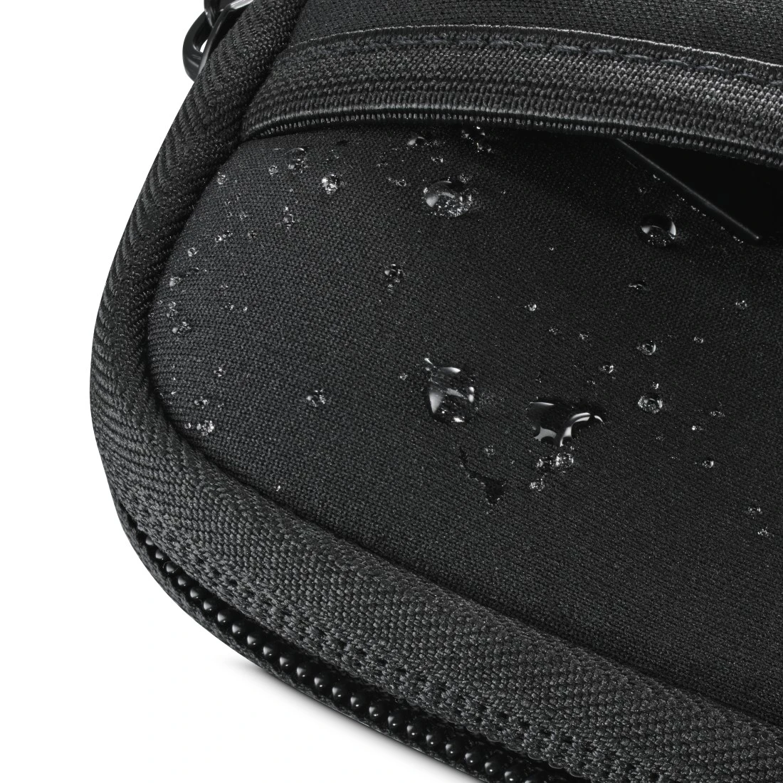 Wassertropfen auf einer wasserabweisenden schwarzen Stofftasche mit Reißverschluss.