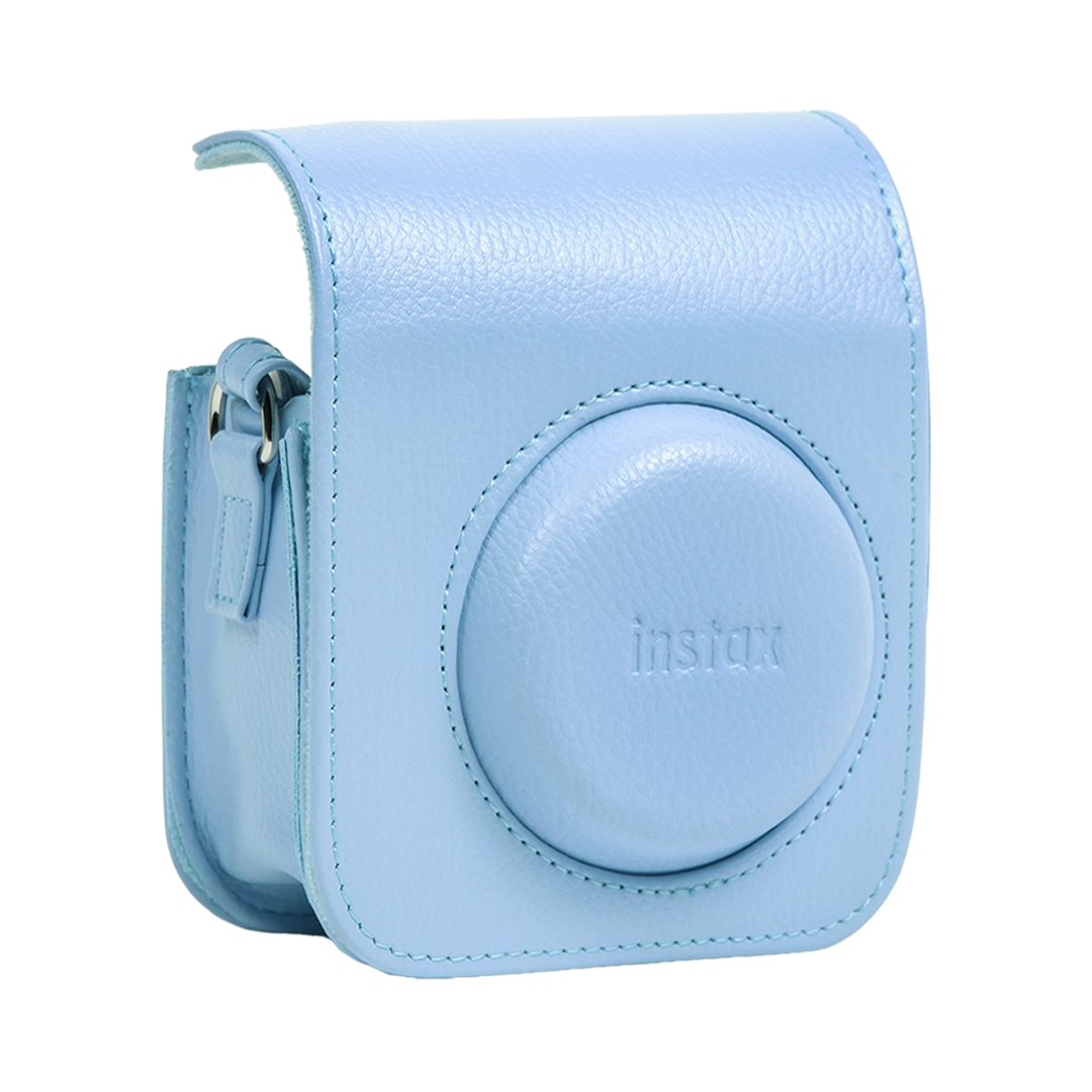 Düz beyaz arka planda yuvarlak lens kapağı ve kabartmalı logo bulunan açık mavi deri Instax kamera kılıfı.