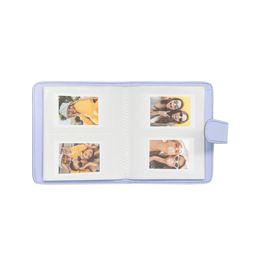 Gülümseyen genç kadınların dört küçük polaroid fotoğrafını içeren açık açık mavi mini fotoğraf albümü.