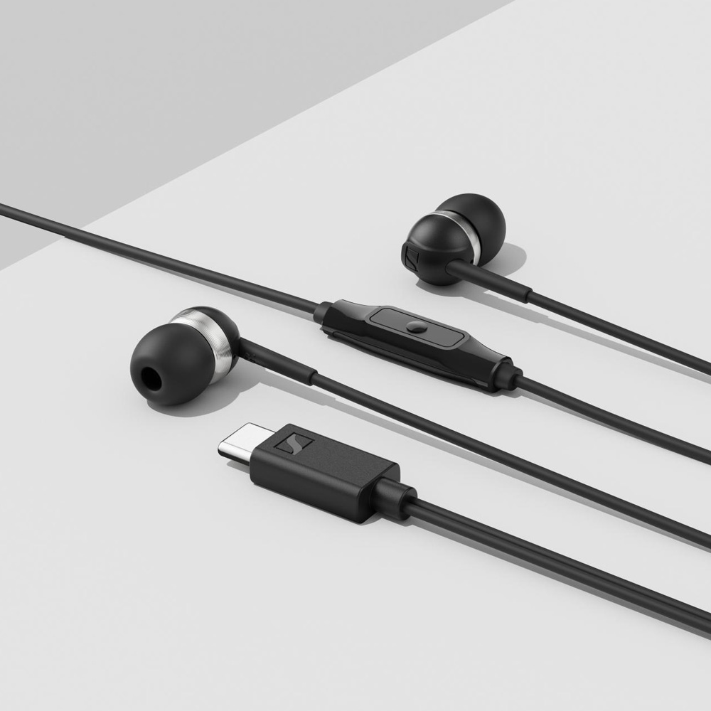 Fekete vezetékes fülhallgató beépített távirányítóval és USB-C csatlakozóval szürke felületen.