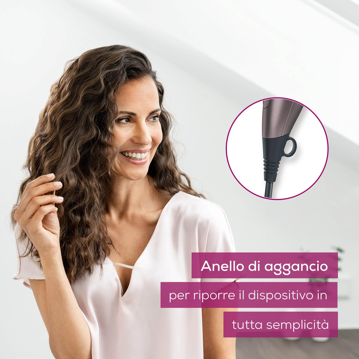 Donna sorridente con capelli ricci e dettaglio di un anello di aggancio dell'asciugacapelli.