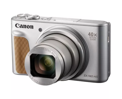Srebrny aparat cyfrowy Canon SX740 HS z brązowym skórzanym uchwytem i wysuniętym obiektywem na białym tle.