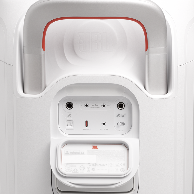 Vista trasera de un dispositivo JBL blanco con asa, varios puertos y etiqueta.