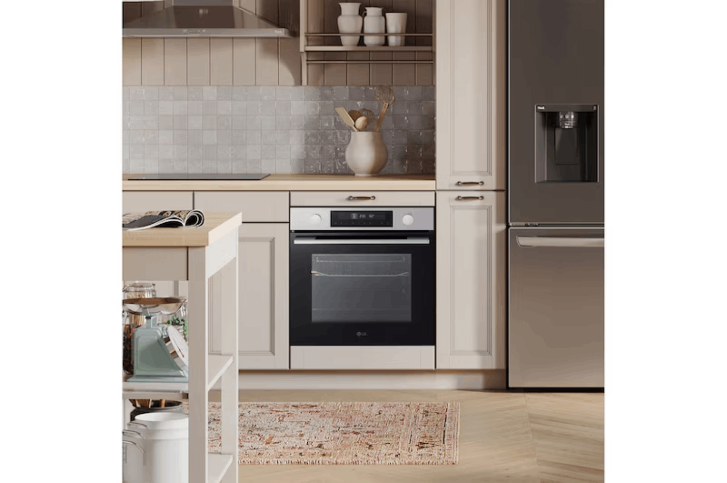 Una cocina moderna con horno empotrado, refrigerador de acero inoxidable, gabinetes claros y alfombra estampada en pisos de madera.