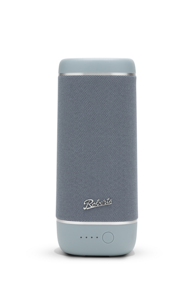 Ein grauer zylindrischer Bluetooth-Lautsprecher von Roberts mit silbernen Akzenten vor schwarzem Hintergrund.