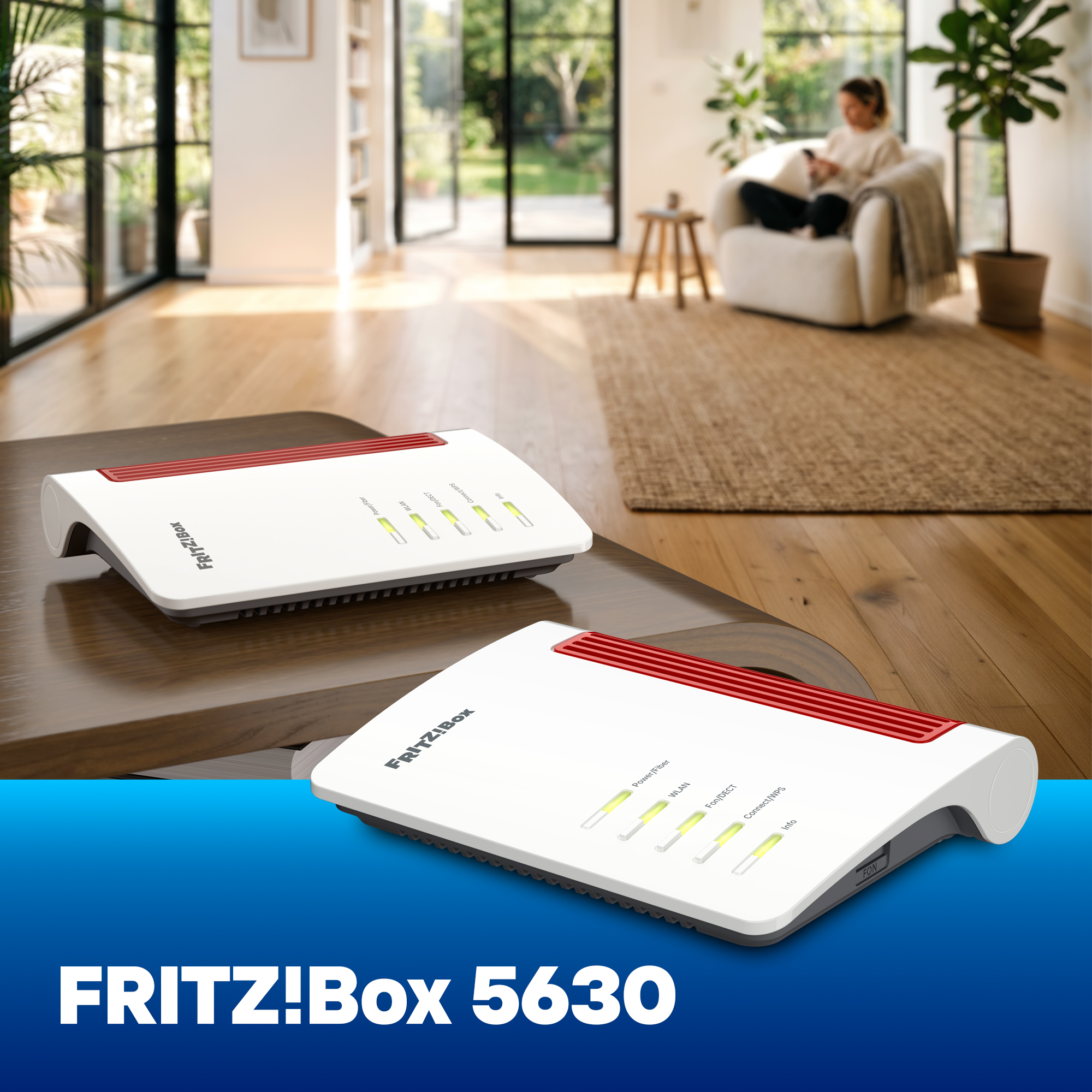 Zwei weiße FRITZ!Box Router stehen auf einem Holztisch, im Hintergrund sitzt eine Person in einem Sessel in einem hellen Raum.