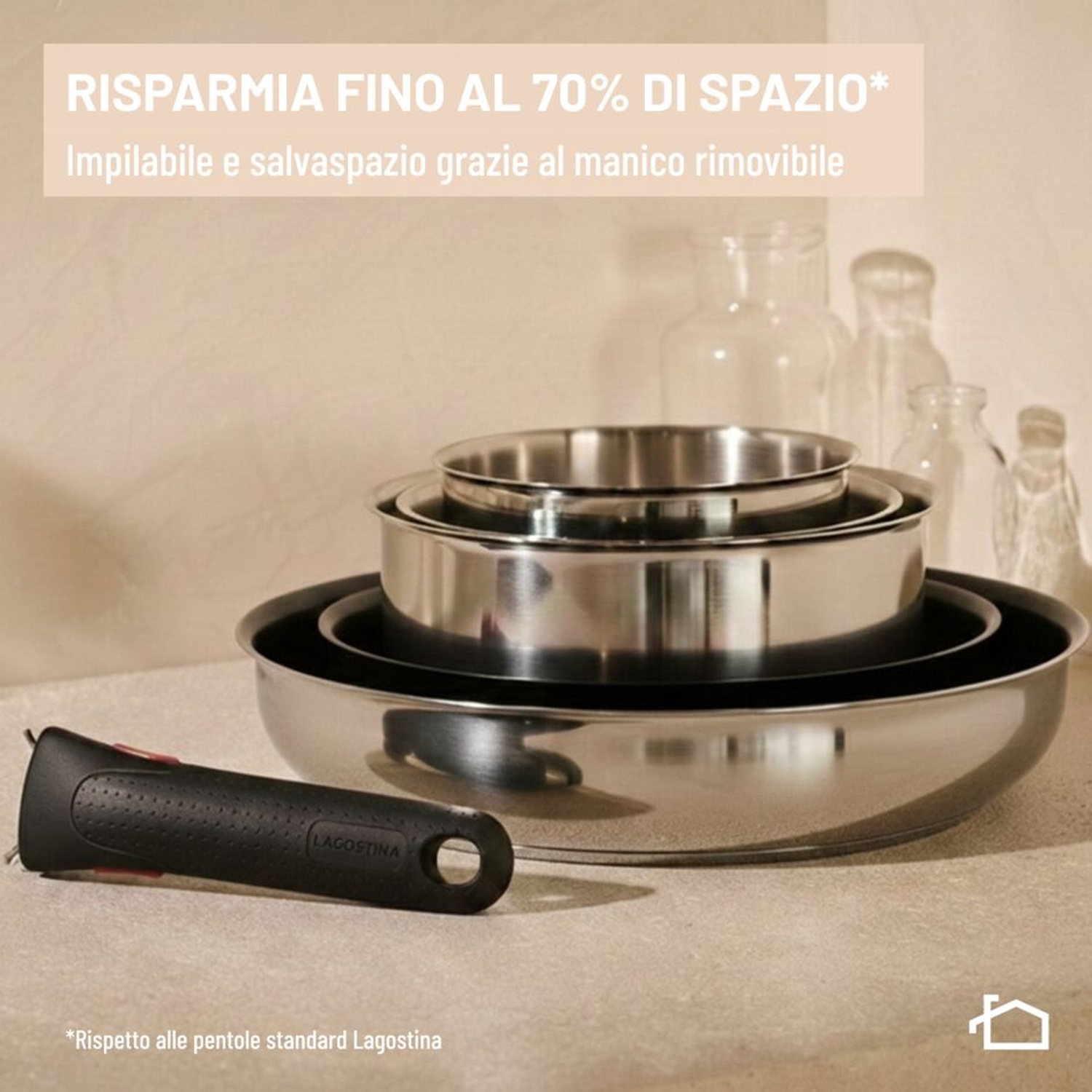 Padelle in acciaio inossidabile impilate con manico nero rimovibile su superficie chiara.