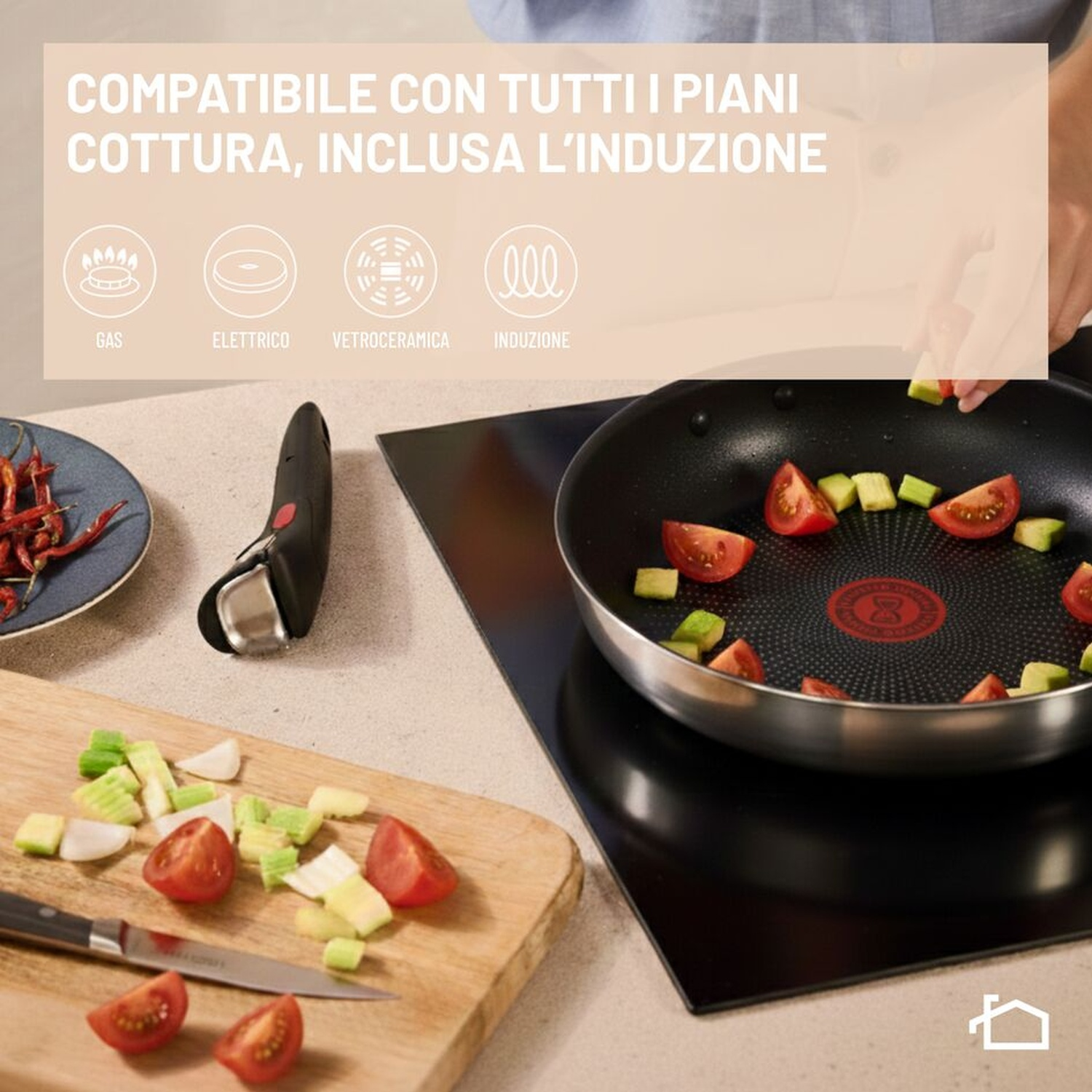 Verdure che cuociono in una padella su piano a induzione, con tagliere e testo di compatibilità.