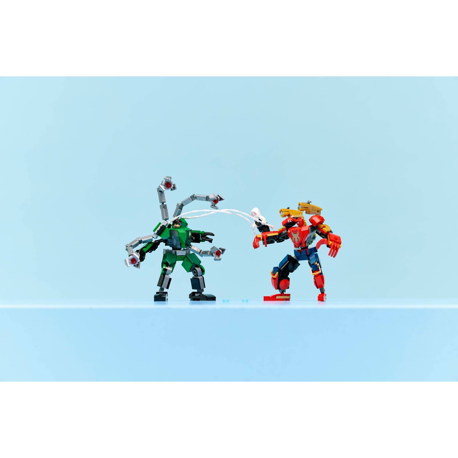 Figure di robot Lego verdi e rosso-blu che combattono su una superficie blu.