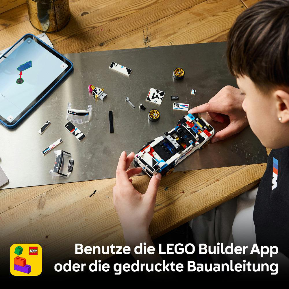 Ein Kind baut ein LEGO Auto auf einer Metallplatte neben einem Tablet mit Bauanleitung.
