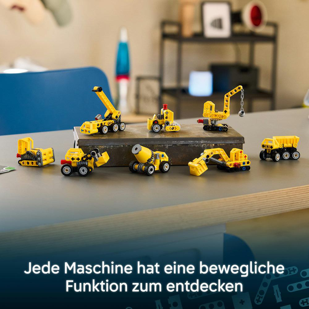 Verschiedene kleine gelbe Lego-Baumaschinen stehen auf einem Tisch in einem Raum.
