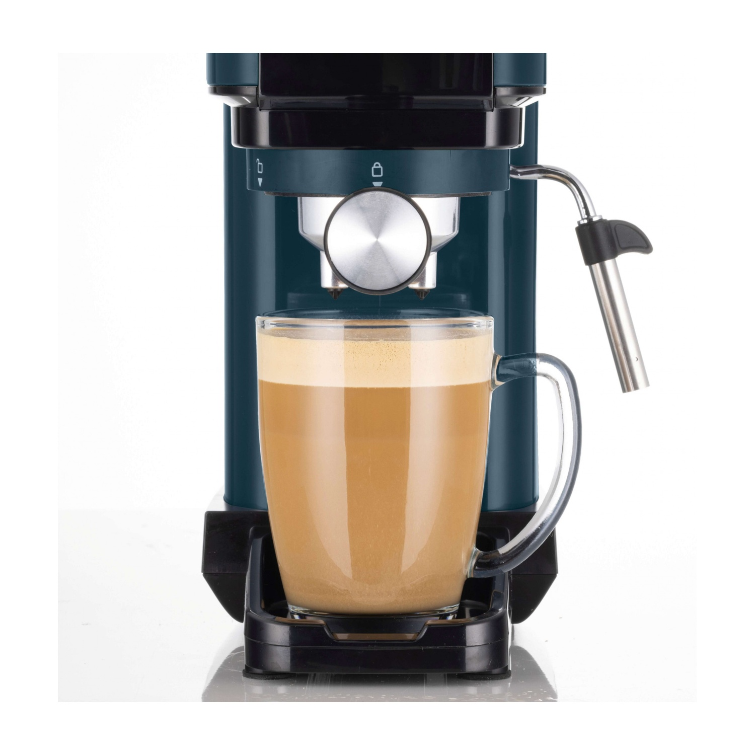 Una macchina da caffè blu e nera riempie una grande tazza di vetro con caffè e schiuma su sfondo bianco.