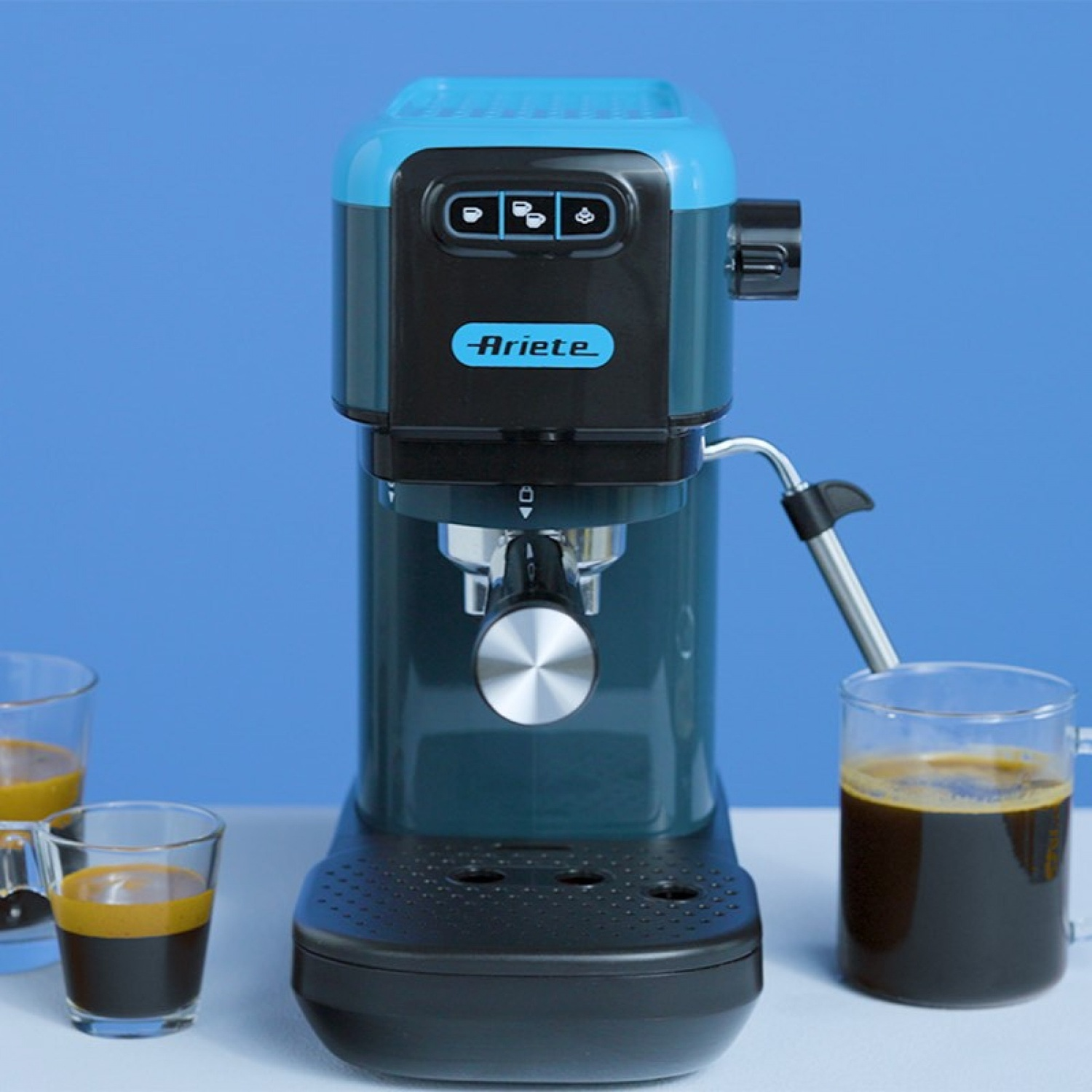 Una macchina da caffè Ariete blu e nera su un tavolo con piccoli bicchieri di caffè.