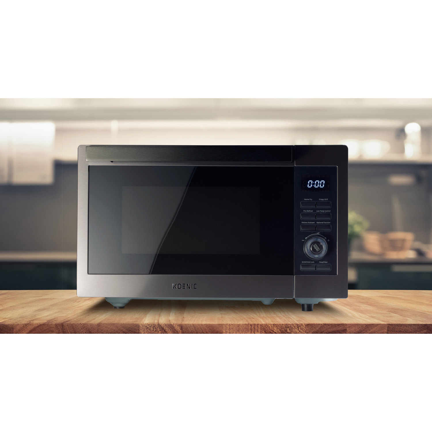 Un microonde grigio Koenic con display digitale si trova su un piano di lavoro in legno in cucina.