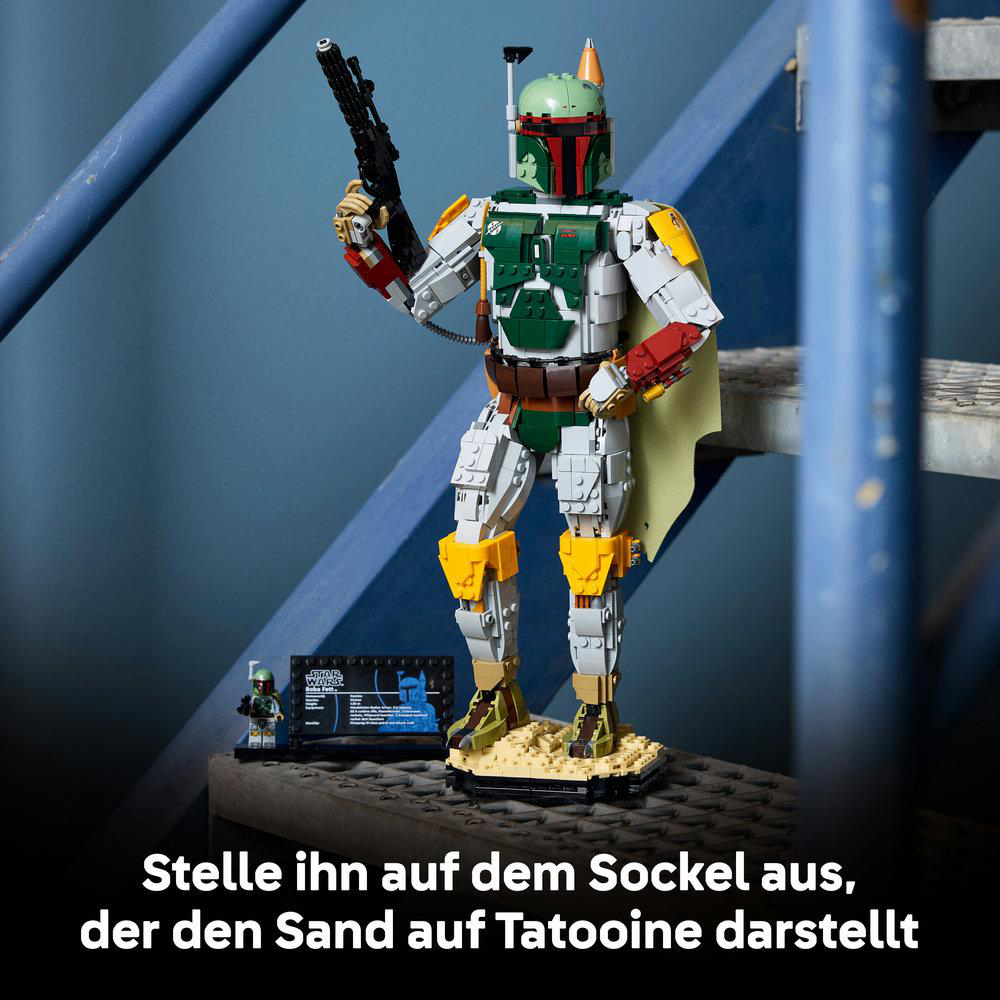Lego-Figur von Boba Fett steht auf einem Sandstand vor blauen Treppen.