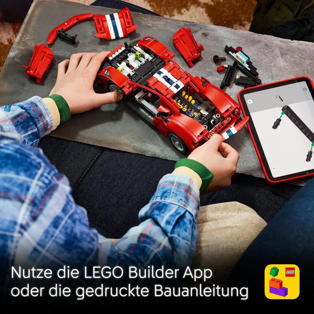 Ein Kind baut ein rotes Lego-Auto mit Tablet-Anleitung.