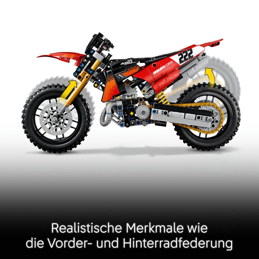 Ein rot-schwarzes Lego Technic Dirt Bike mit sichtbarer Federung vor weißem Hintergrund.