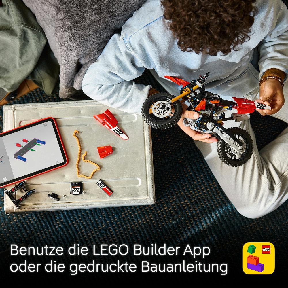 Ein Kind baut ein Lego Motorrad und nutzt dabei ein Tablet mit einer App.