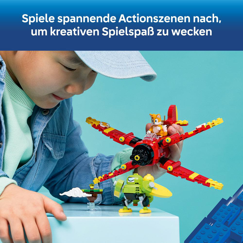 Ein Kind baut und spielt mit einem roten Lego Sonic Flugzeug und einer grünen Roboterfigur.