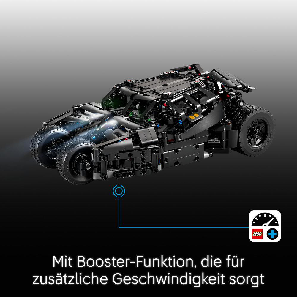 Schwarzes Lego Batmobil mit leuchtenden Frontlichtern auf grauem Hintergrund und deutscher Text.