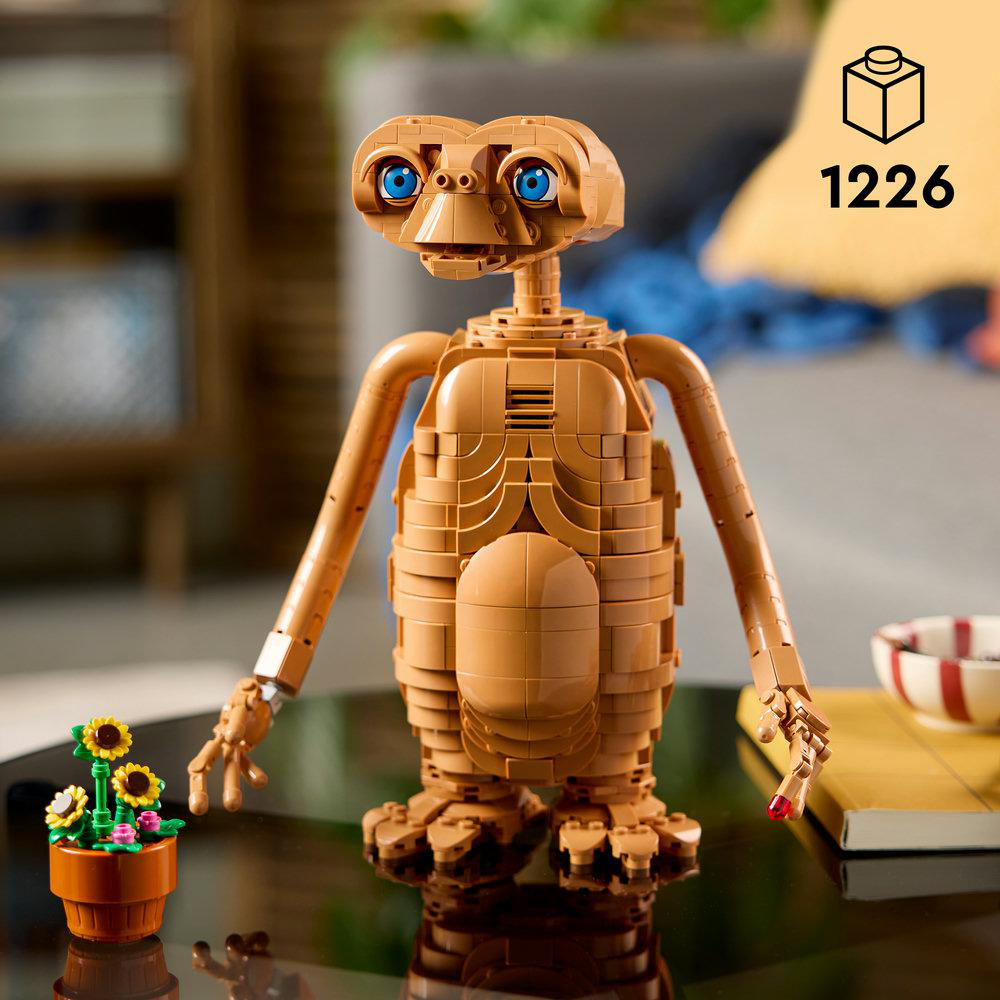 E.T. LEGO-Figur stehend vor einem Tisch mit einer kleinen Topfpflanze.