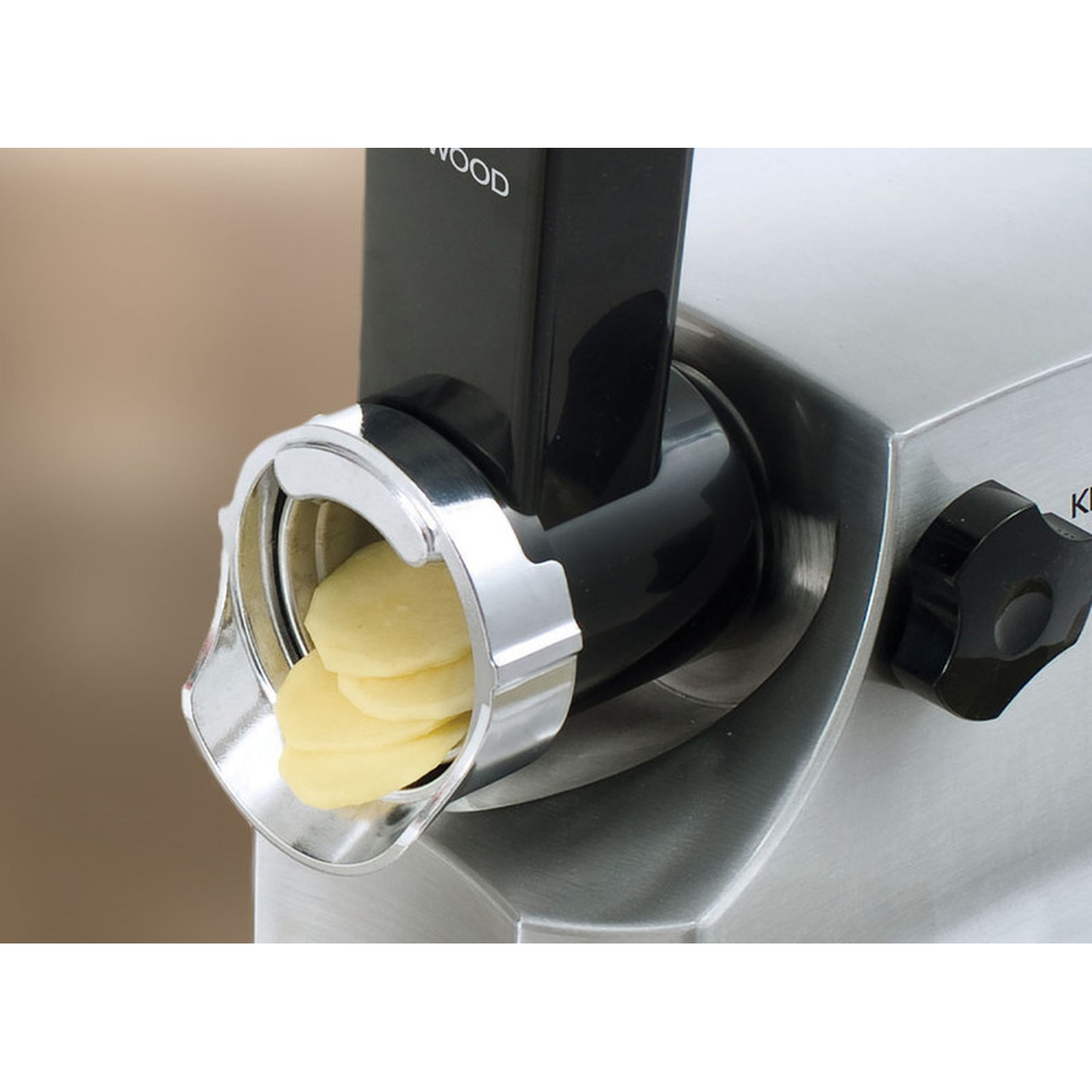 Fette di patate escono dall'accessorio di un robot da cucina.