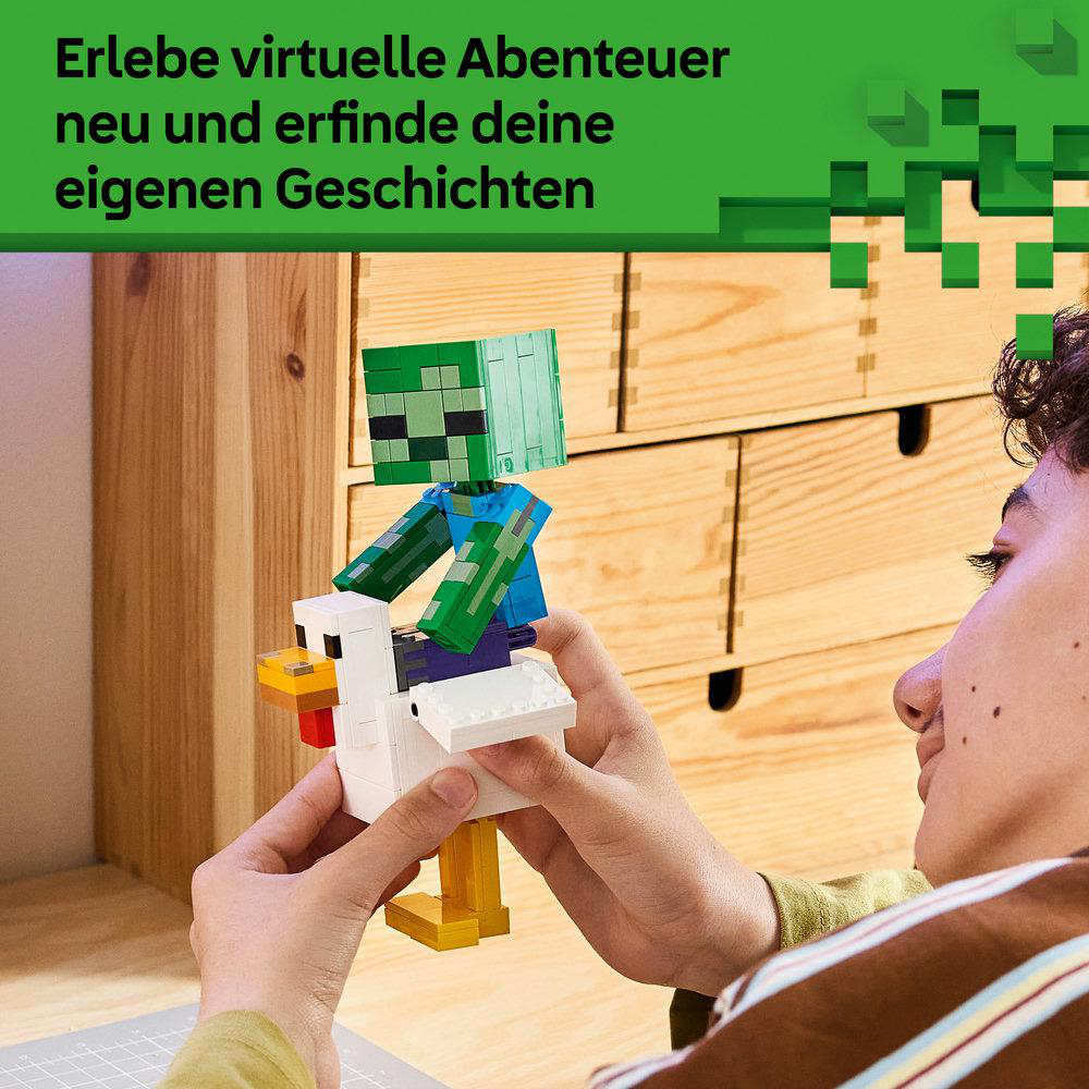 Eine Person baut ein Minecraft-Lego-Set mit einem Zombie auf einem Huhn vor einer Holzschublade.
