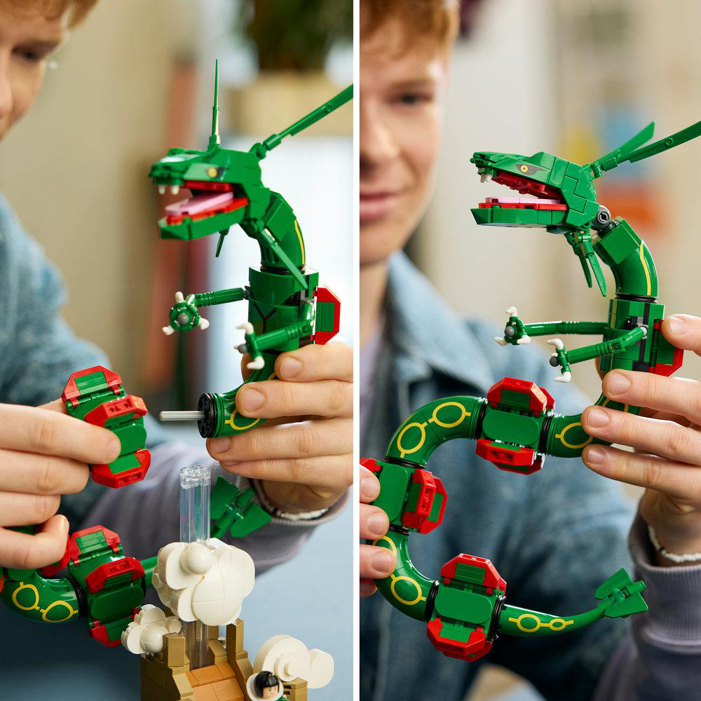 Eine Person baut einen grünen Legodrachen zusammen, der auf weißen Wolken schwebt.