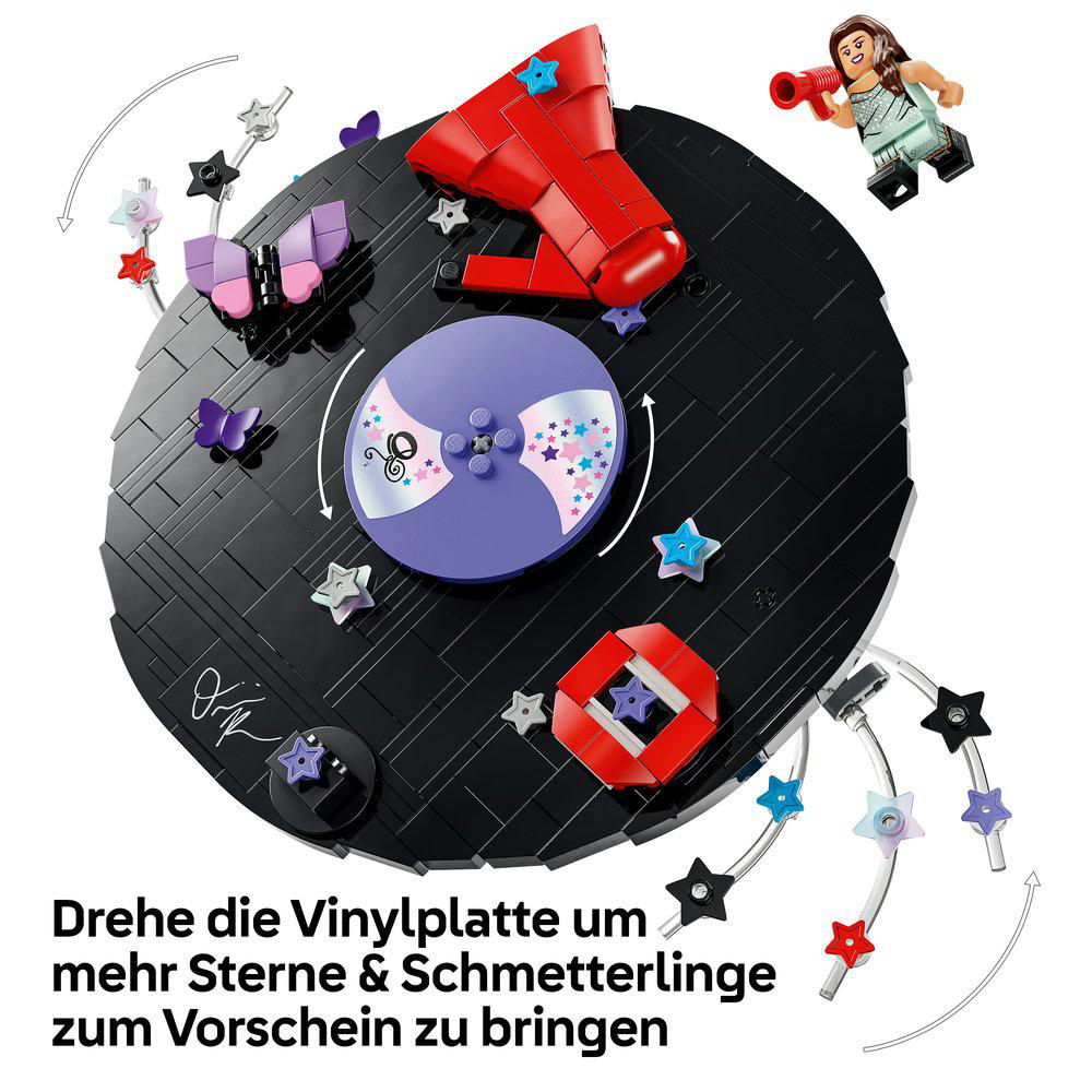 Lego-Vinylplatte mit bunten Sternen, Schmetterlingen und einer Minifigur oben rechts.