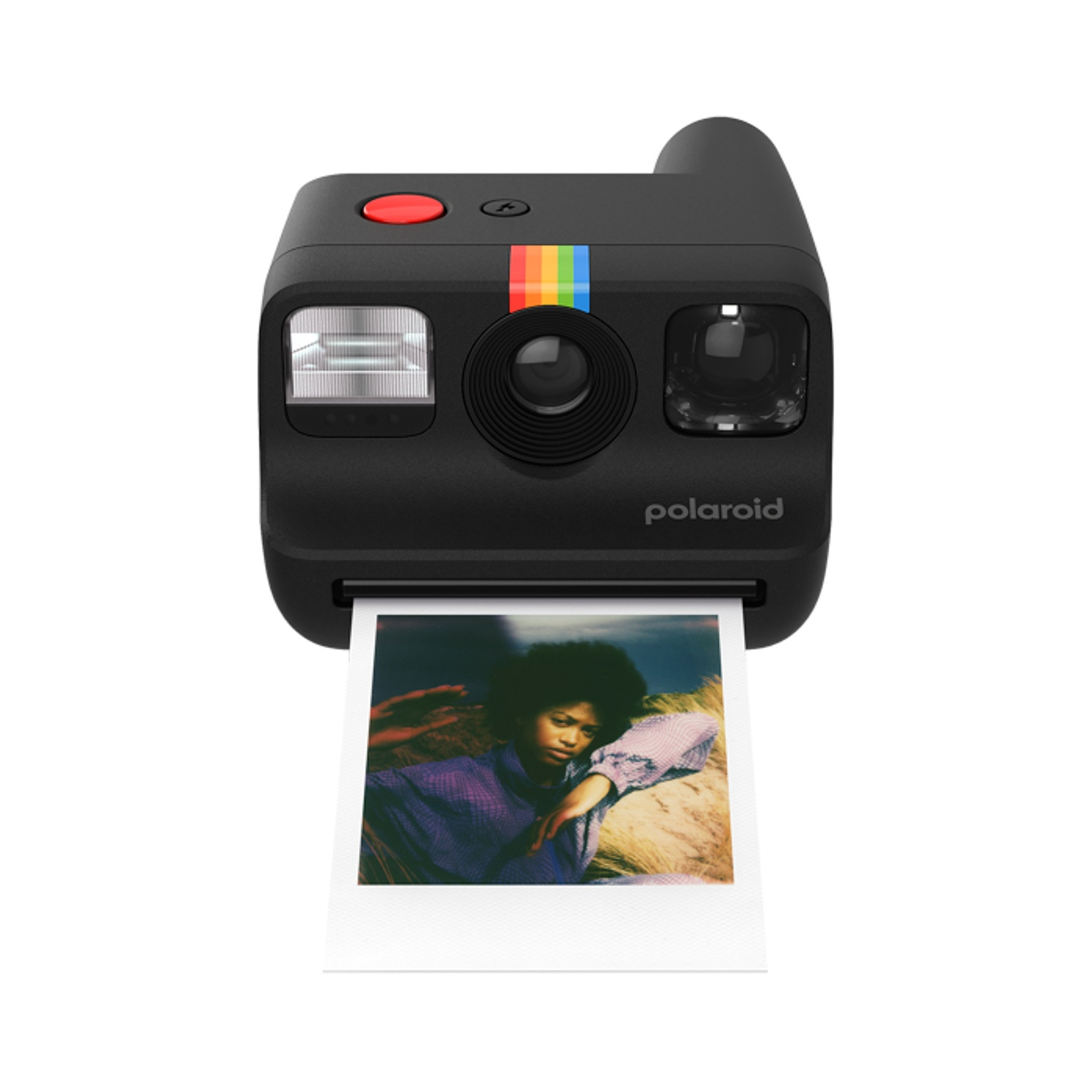 Una fotocamera istantanea Polaroid nera che stampa la foto di una persona all'aperto.