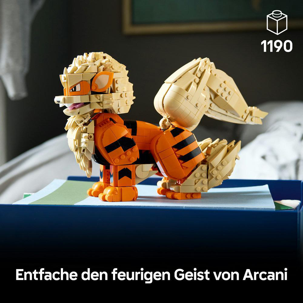 Ein LEGO-Modell des Pokémon Arkani steht auf einer blauen Schachtel in einem Raum, mit orangen, schwarzen und beigen Steinen.
