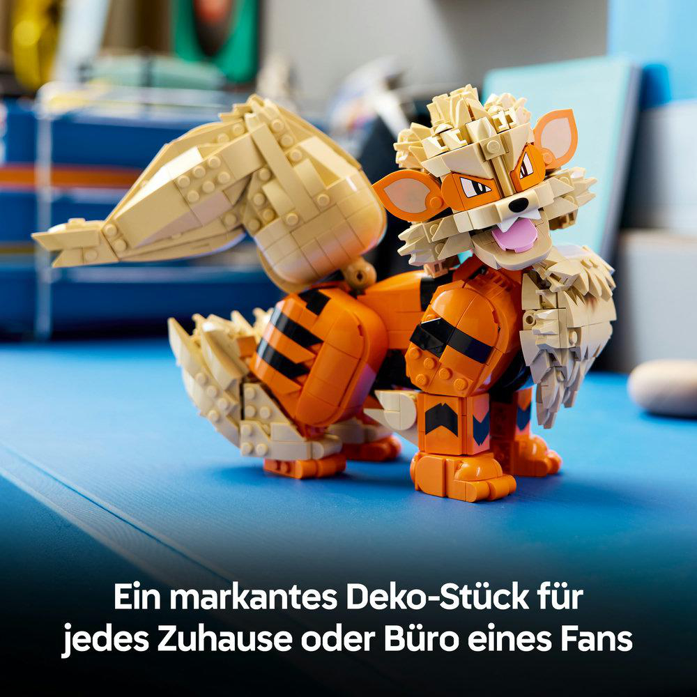 Eine orange-beige Lego-Figur eines Pokémon mit grossem Schwanz auf blauem Tisch.