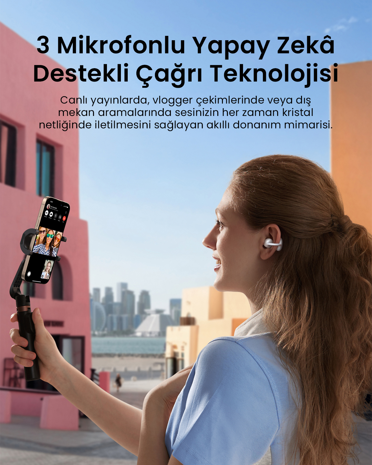 Kulaklık takan bir kadın, arka planda renkli binalarla bir gimnbal üzerinde akıllı telefon tutuyor.