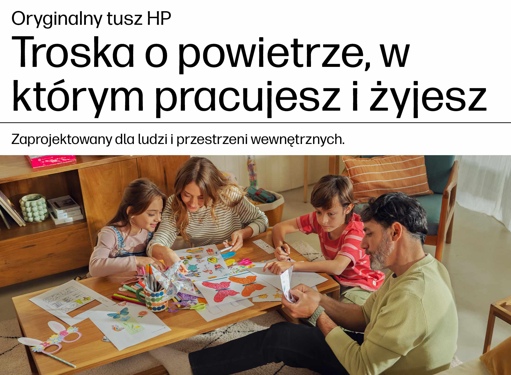 Rodzina siedzi przy drewnianym stole w przytulnym salonie, rysując i tworząc razem.