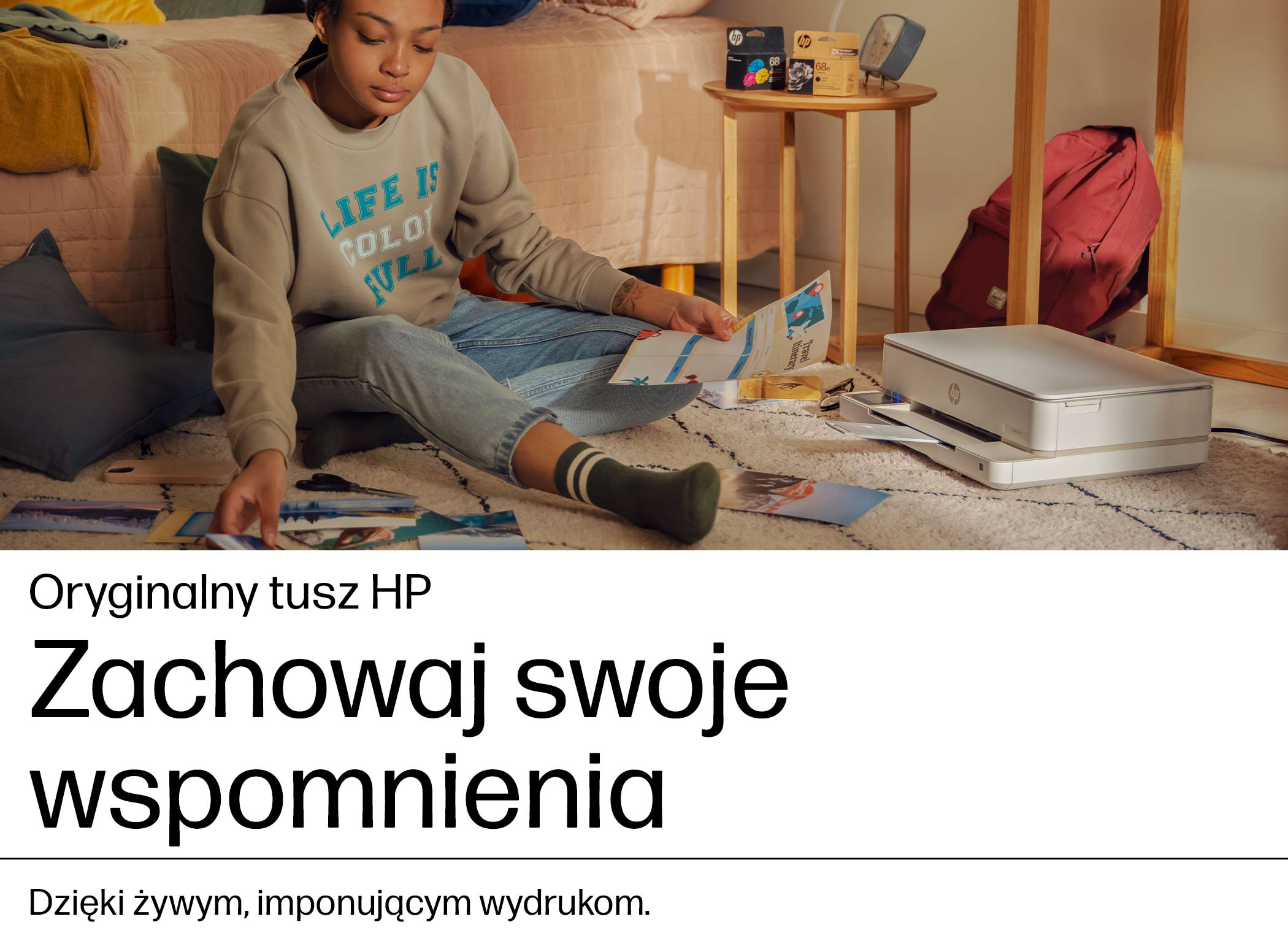 Kobieta siedzi na dywanie i segreguje wydrukowane zdjęcia, obok stoi drukarka.