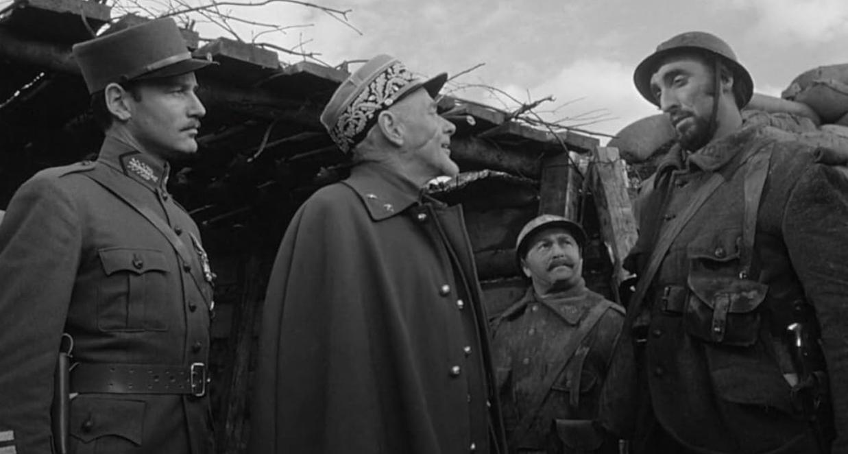 Vier Soldaten in Uniform unterhalten sich in einem Schützengraben während eines Krieges.
