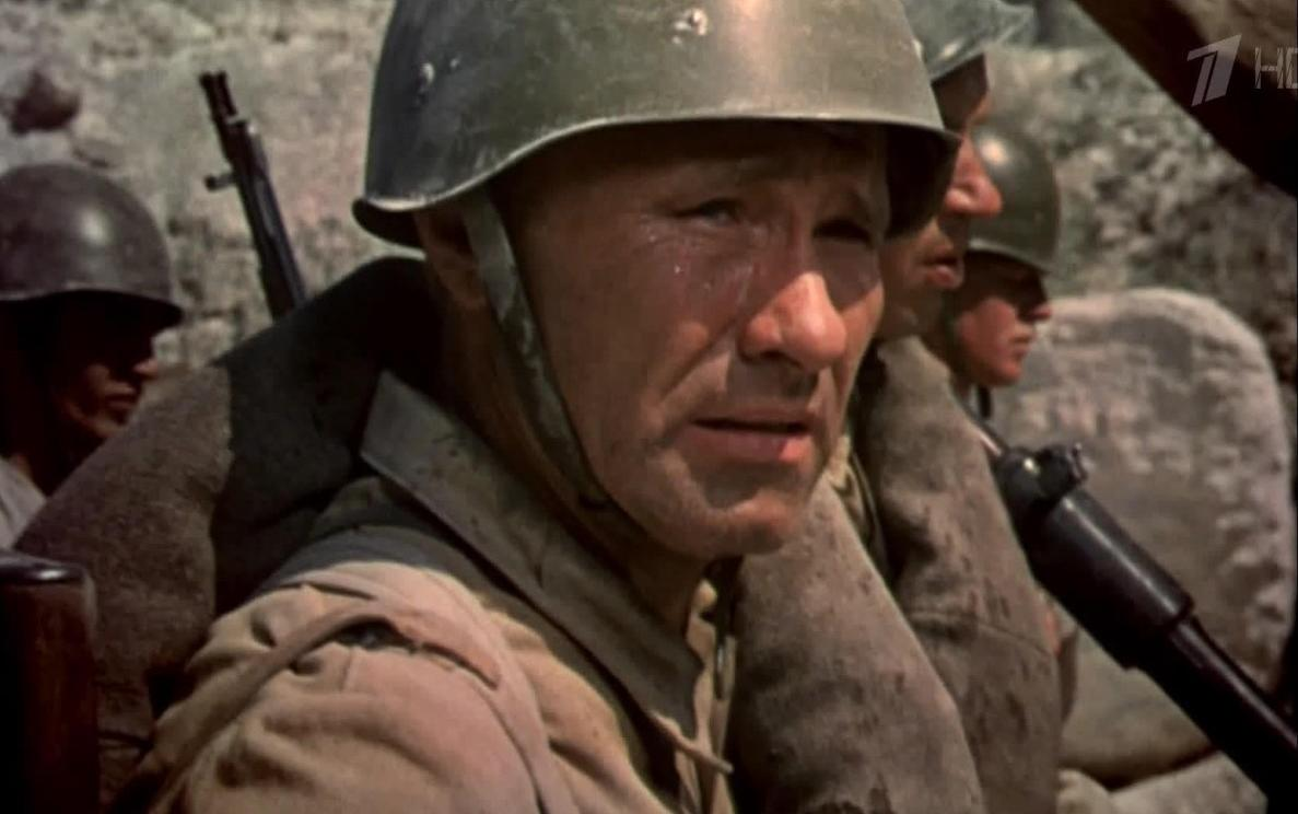 Mehrere Soldaten in Uniform und Helmen stehen in einem Schützengraben.